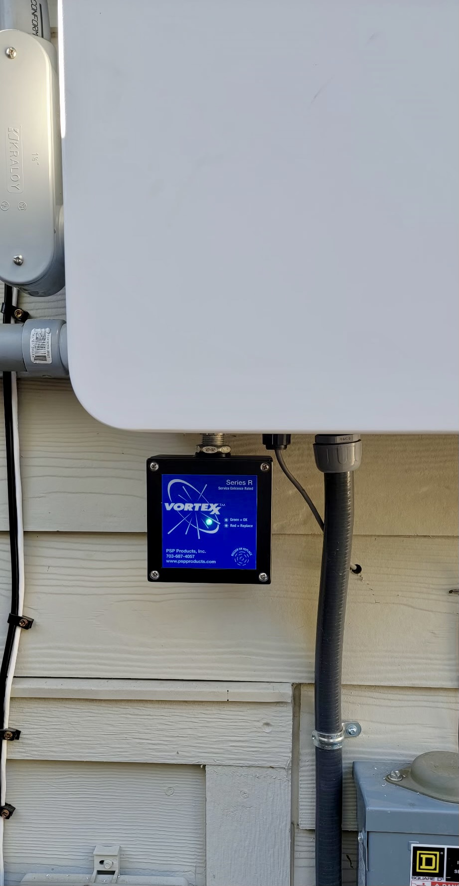 Whole-home surge protector installed next to an electrical panel in a Boise home, with a green status light showing it's active